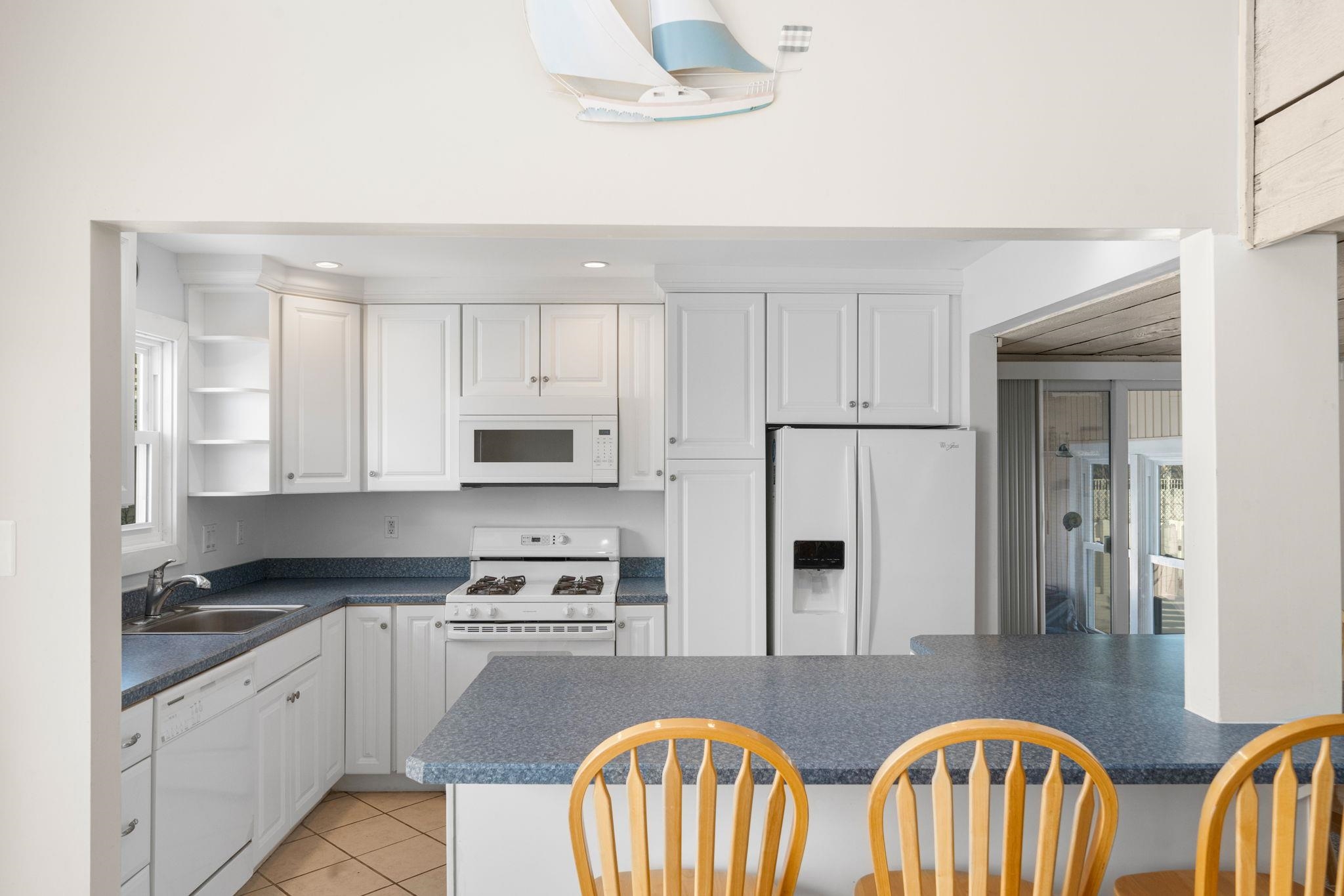 45 19th Street Avalon, NJ 08202 - Photo 13 of 50 a kitchen with stainless steel appliances granite countertop a sink a stove a refrigerator a microwave oven with cabinets and wooden floor