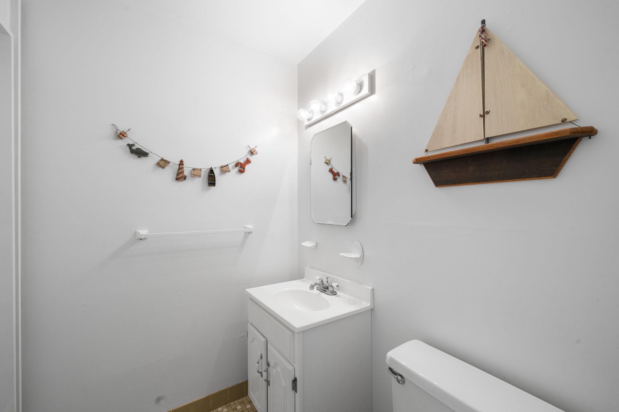 45 19th Street Avalon, NJ 08202 - Photo 22 of 50 a bathroom with a sink a toilet and a mirror