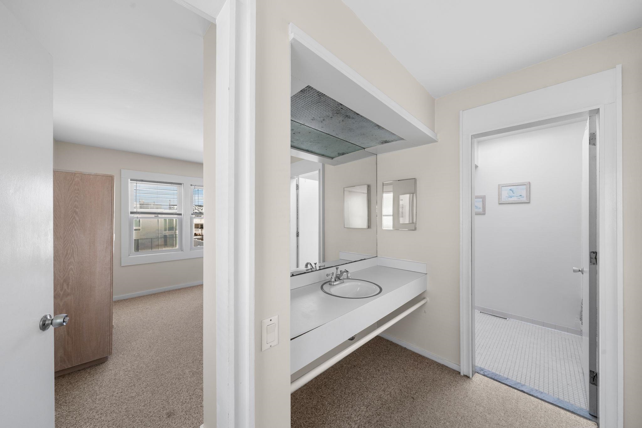 45 19th Street Avalon, NJ 08202 - Photo 26 of 50 a bathroom with a granite countertop sink and mirror