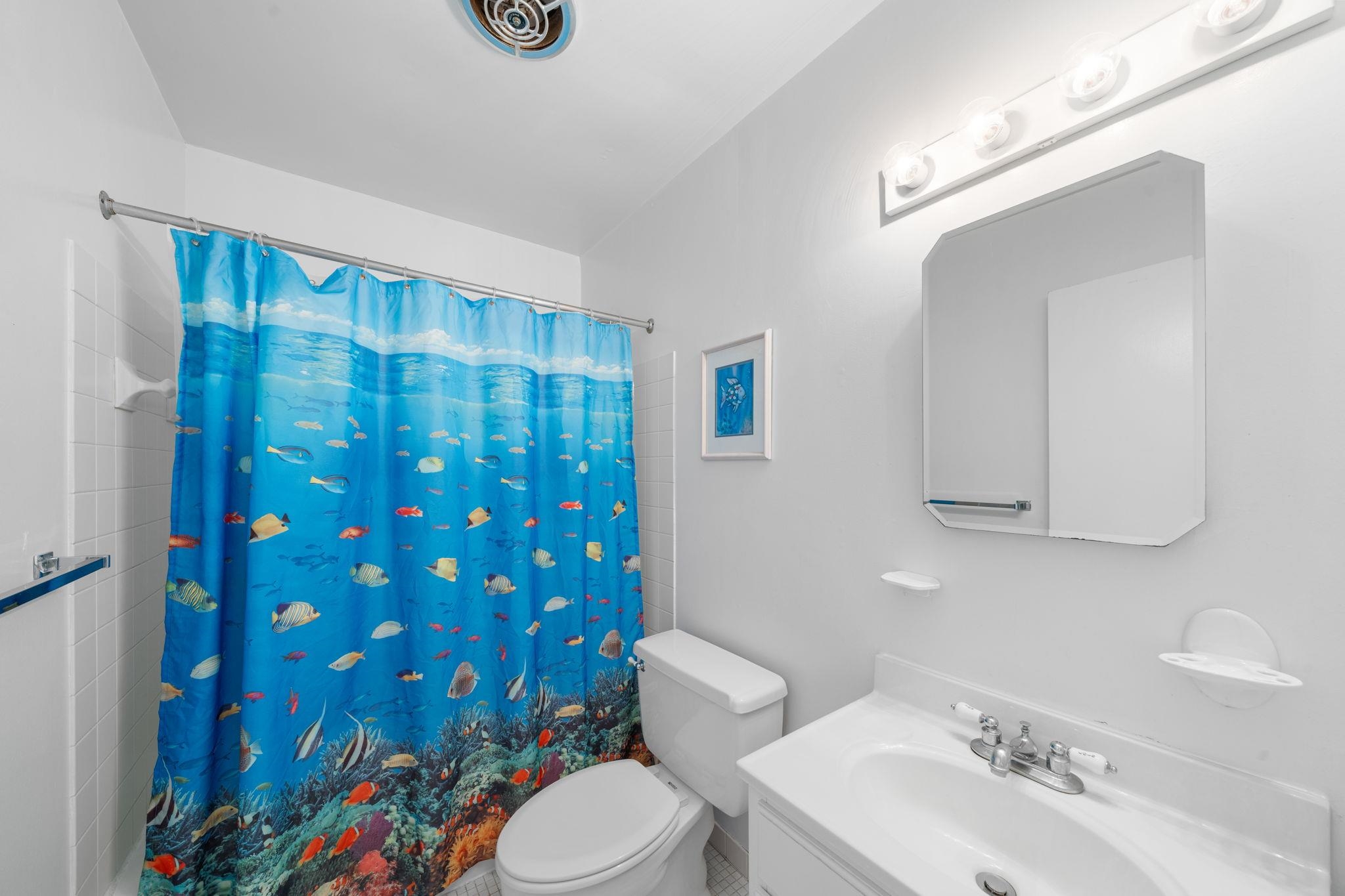45 19th Street Avalon, NJ 08202 - Photo 36 of 50 a bathroom with a sink a toilet and shower curtain
