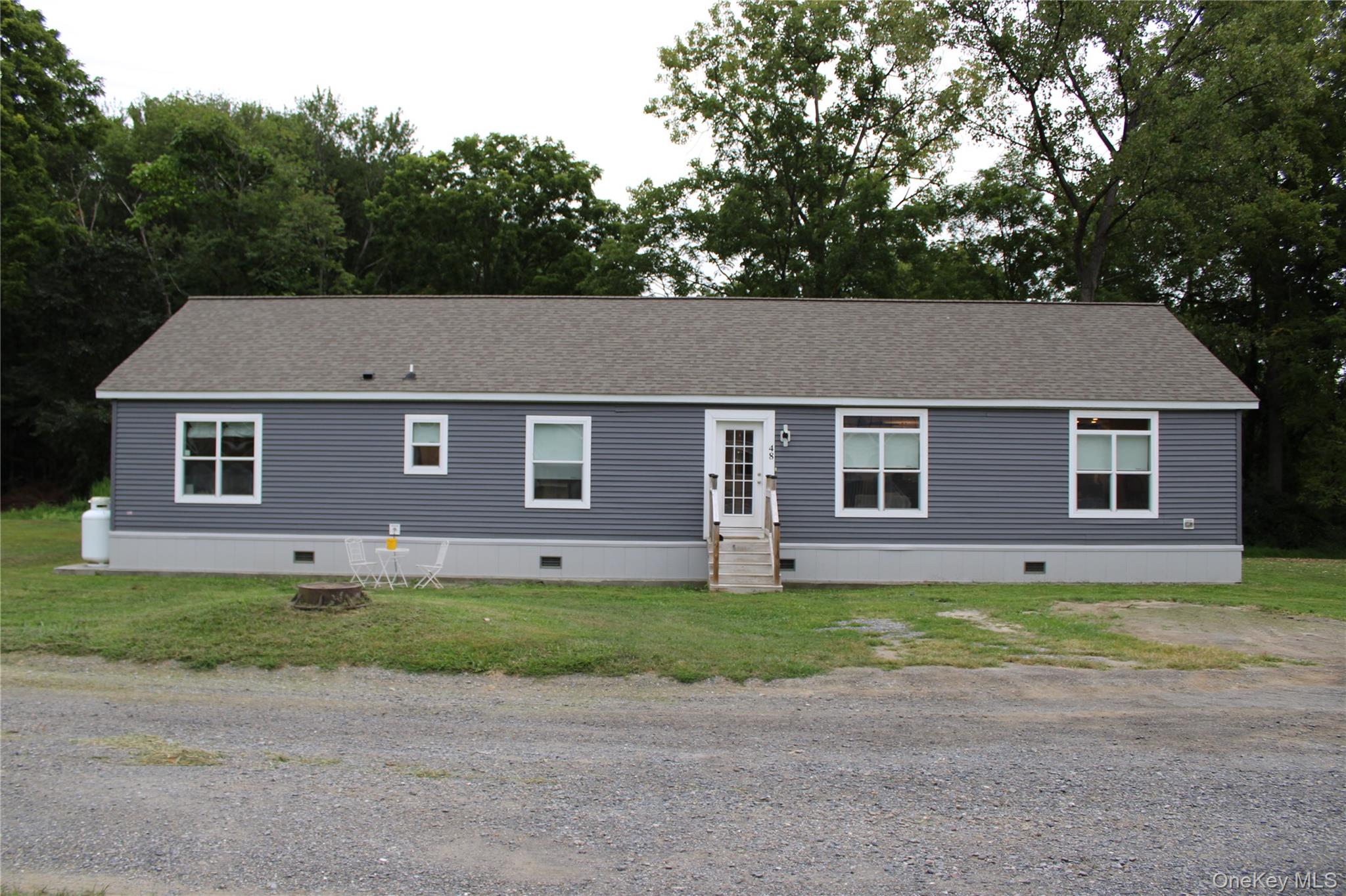 View of front of house with crawl space, entry steps, and a shingled roof