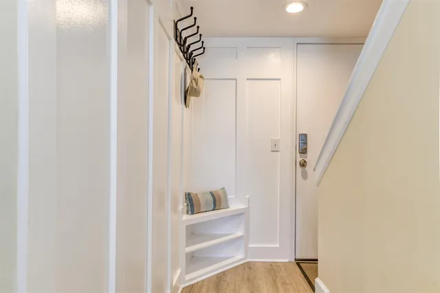a view of a hallway with wooden floor and windows