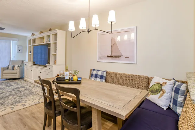 a living room with furniture a flat screen tv and kitchen view