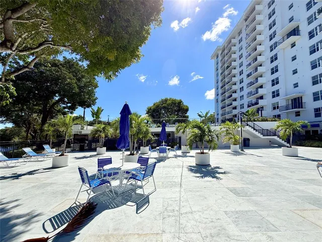a view of a patio with table and chairs and floor to ceiling window