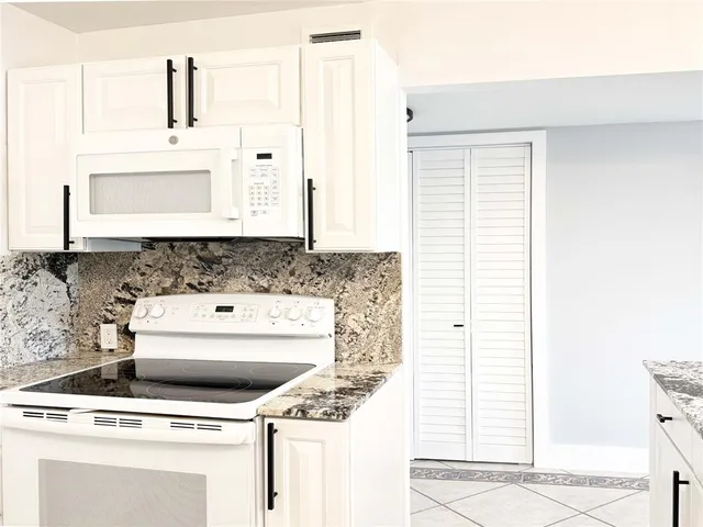a living room with a bed furniture and a kitchen view