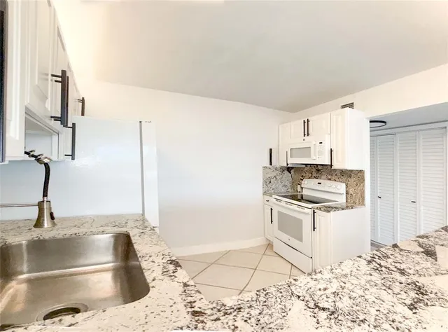 a dining room with furniture and a kitchen view