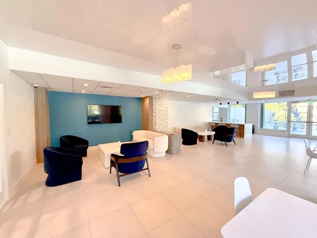 a large white kitchen with lots of counter space and windows