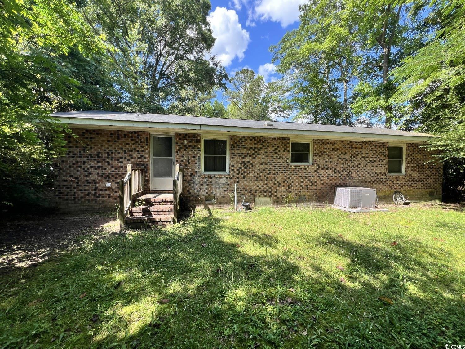 41 Harmon Street Hemingway, SC 29554 - Photo 6 of 20 Back of property with central air condition unit, a yard, brick siding, and crawl space