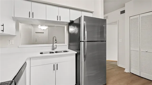 a kitchen with a refrigerator sink and cabinets