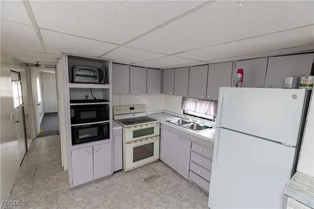 a kitchen with refrigerator cabinets and stove top oven