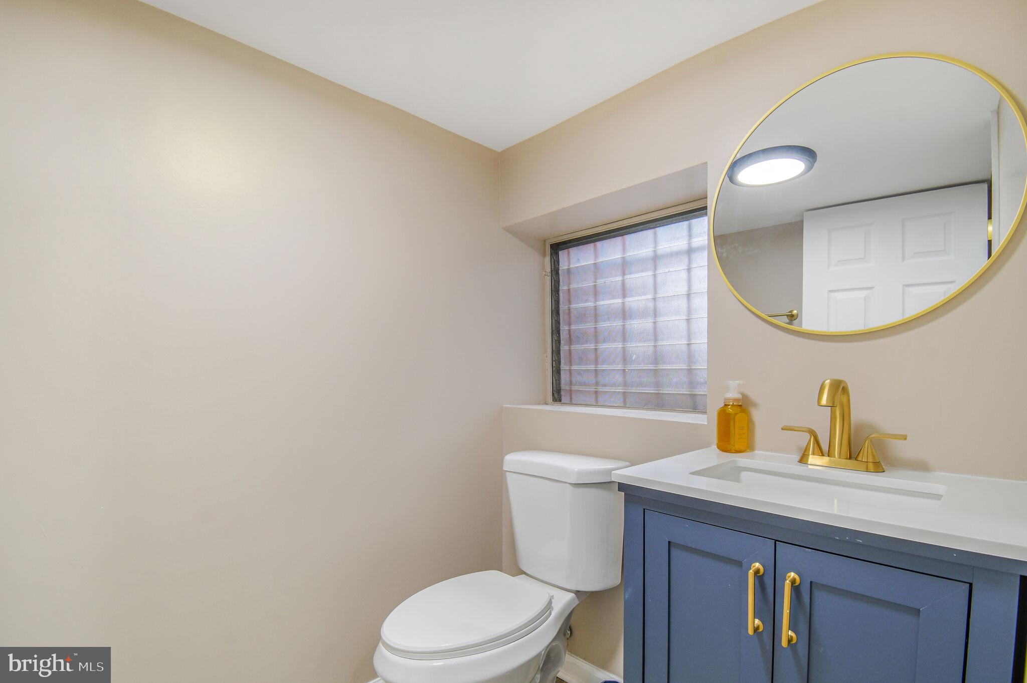 636 5th Street Northeast Washington, DC 20002 - Photo 11 of 16 a bathroom with a toilet a sink a mirror and vanity