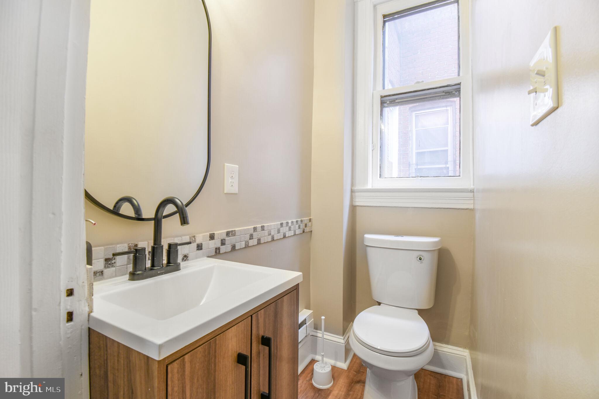 636 5th Street Northeast Washington, DC 20002 - Photo 12 of 16 a bathroom with a toilet sink and mirror