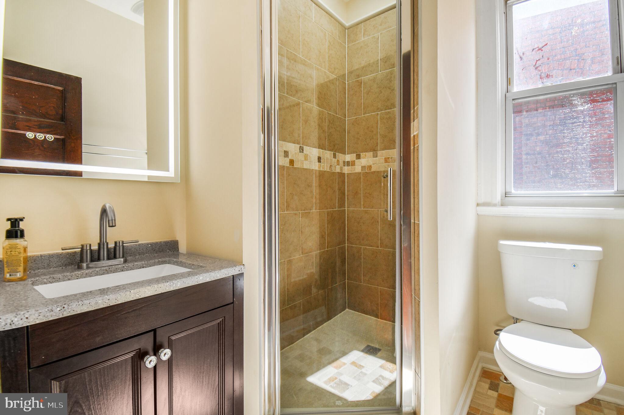 636 5th Street Northeast Washington, DC 20002 - Photo 10 of 16 a bathroom with a granite countertop sink toilet and shower