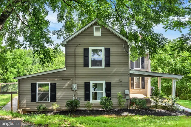 a front view of a house with a yard and potted plants