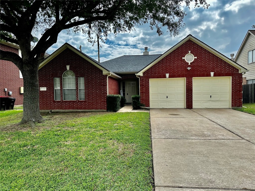 23023 Canal Road Richmond, TX 77406 - Photo 1 of 30 a front view of a house with a garden and yard