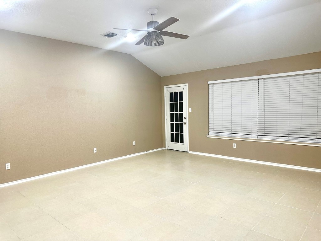 23023 Canal Road Richmond, TX 77406 - Photo 14 of 30 an empty room with chandelier fan and windows