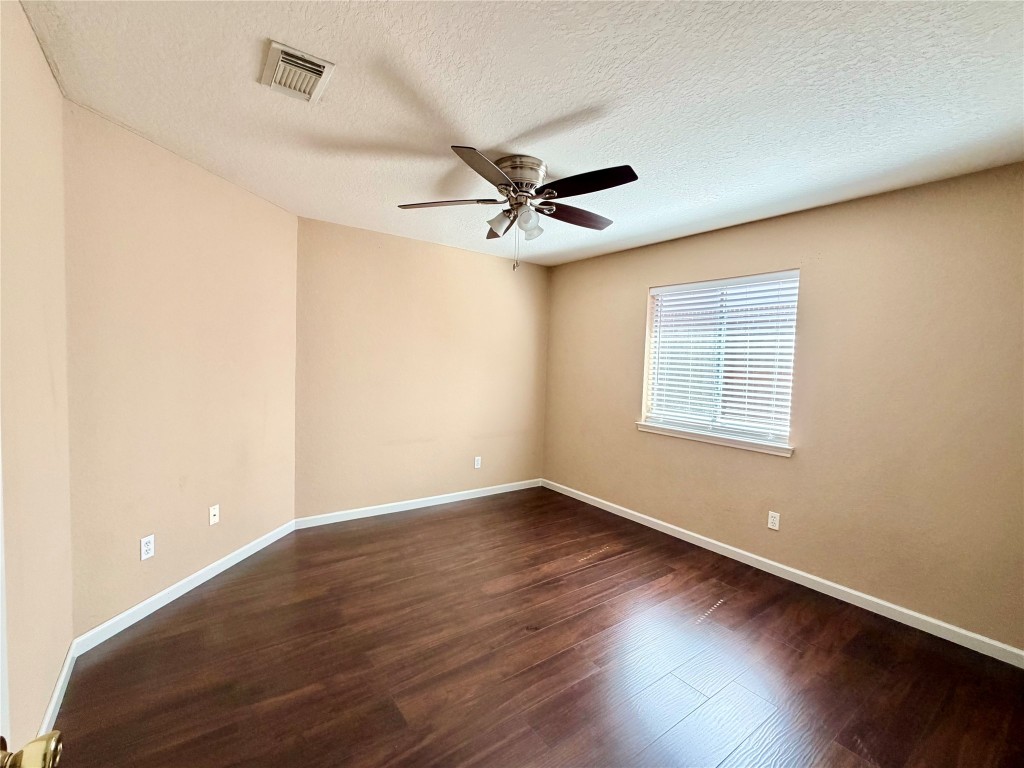 23023 Canal Road Richmond, TX 77406 - Photo 23 of 30 an empty room with wooden floor and ceiling fan