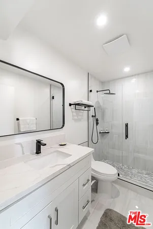 a bathroom with a granite countertop sink toilet and shower