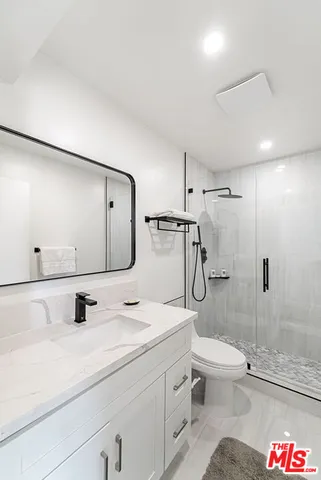 a bathroom with a granite countertop sink toilet and shower