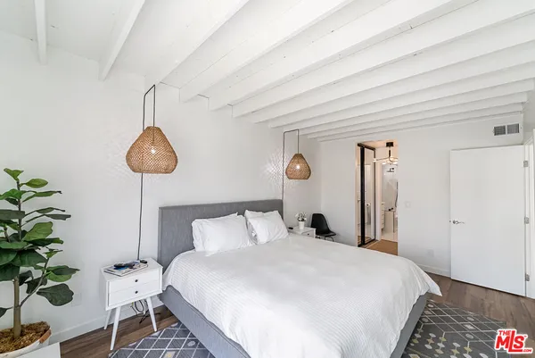a bedroom with bed and a potted plant