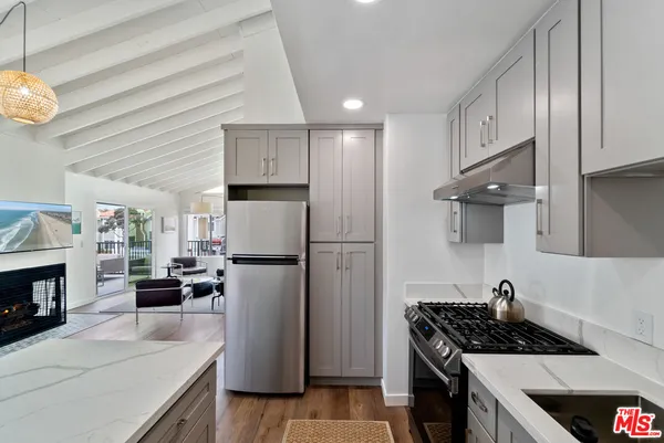a kitchen with a refrigerator a stove cabinets and a dining table