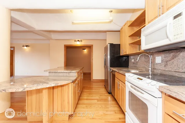a kitchen with granite countertop a sink and cabinets