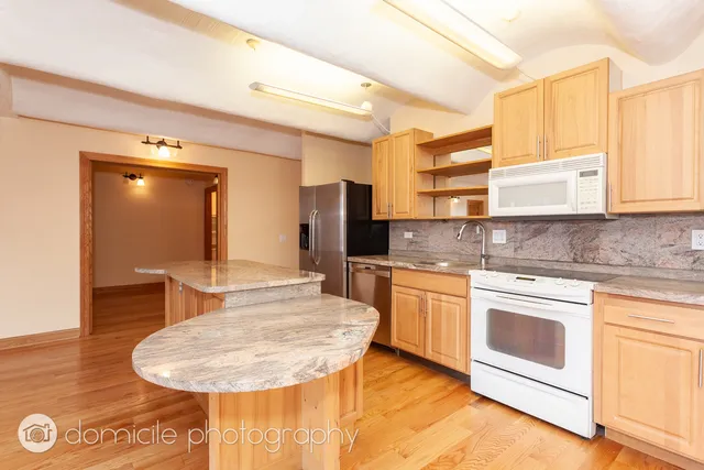 a kitchen with stainless steel appliances granite countertop a sink and cabinets