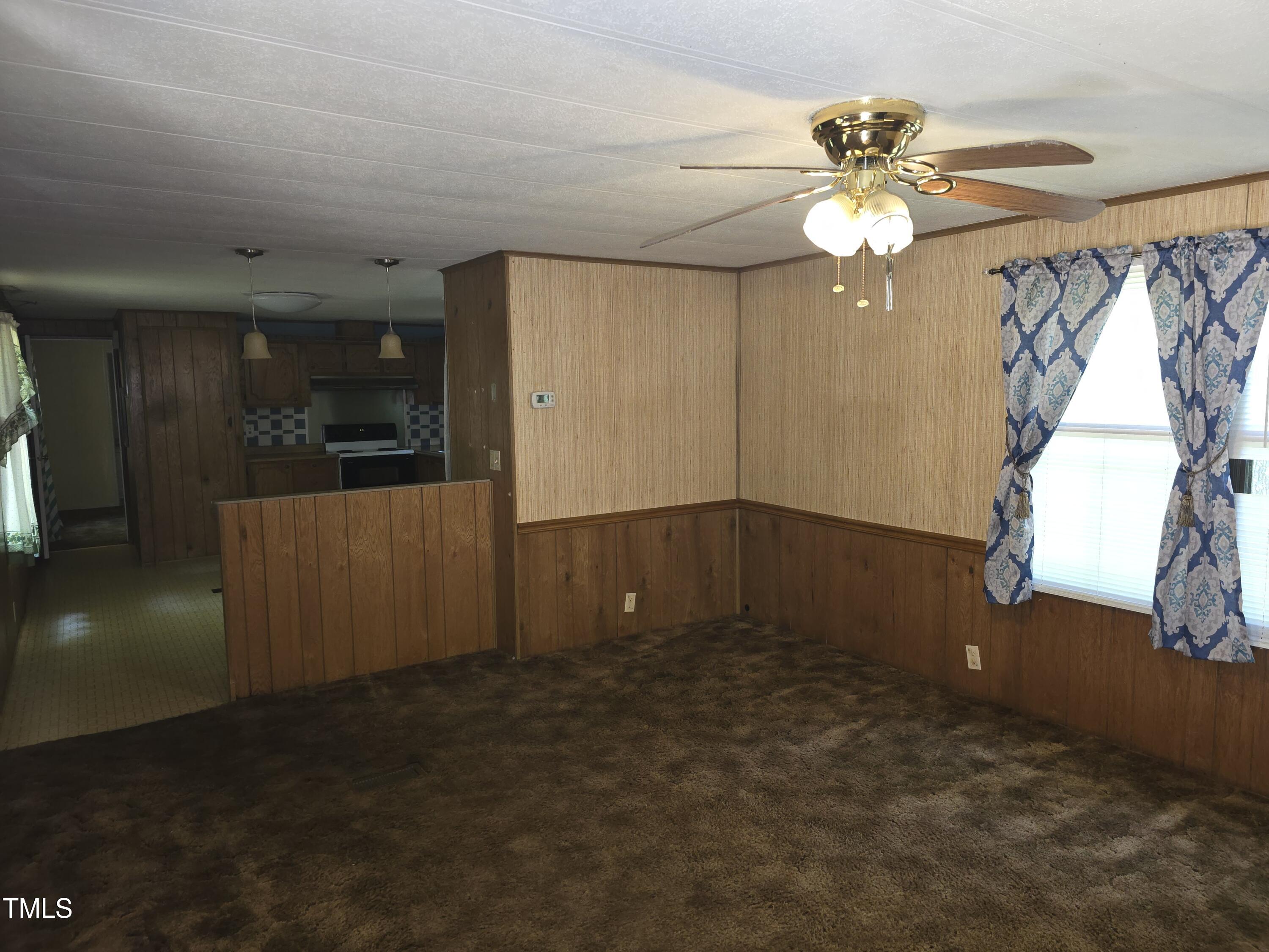 1337 Carroll Heights Road Zebulon, NC 27597 - Photo 5 of 9 en empty room with windows and fan