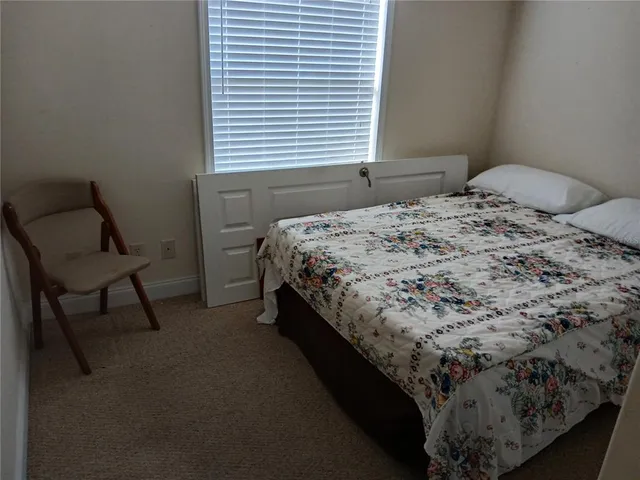 a bedroom with a bed chair and a window