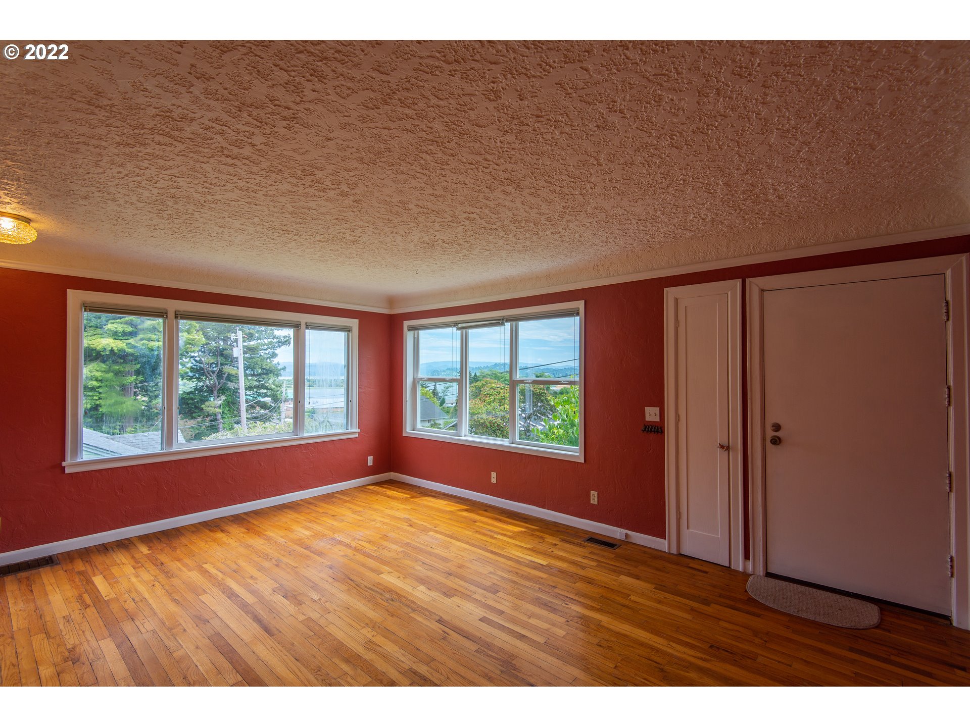 544 Clark Street North Bend, OR 97459 - Photo 7 of 32 a view of an empty room with wooden floor and a window