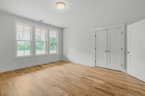 an empty room with windows and closet