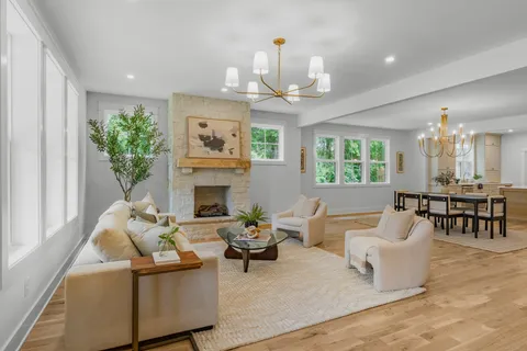 a living room with furniture a chandelier and a fireplace