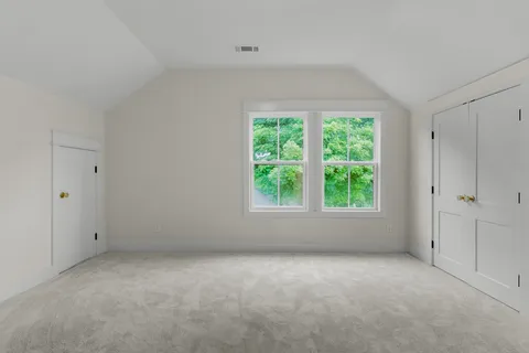 an empty room with a fan & a ceiling fan