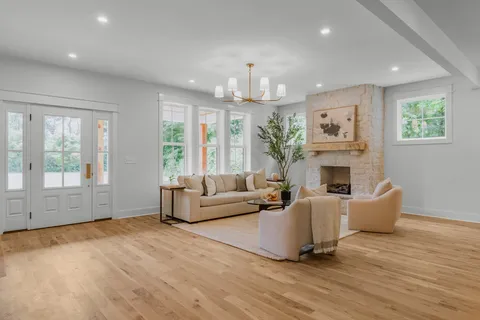 a living room with furniture a large window and a fireplace