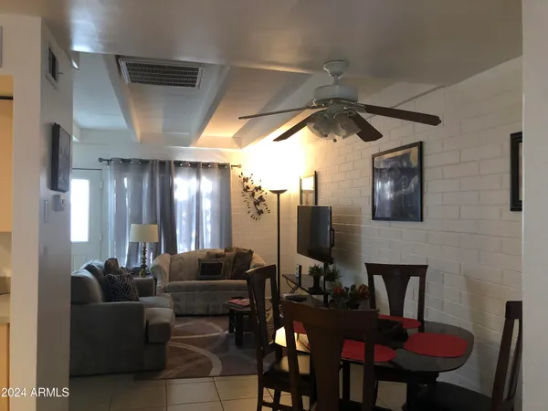 a living room with furniture a ceiling fan and a rug