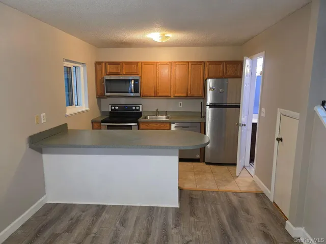 a kitchen with kitchen island a counter top space a refrigerator and a sink