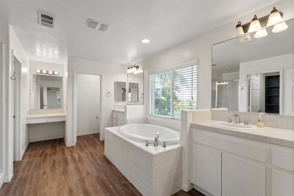 1049 Boulder Place Oceanside, CA 92057 - Photo 22 of 49 a bathroom with a tub a sink and mirrors