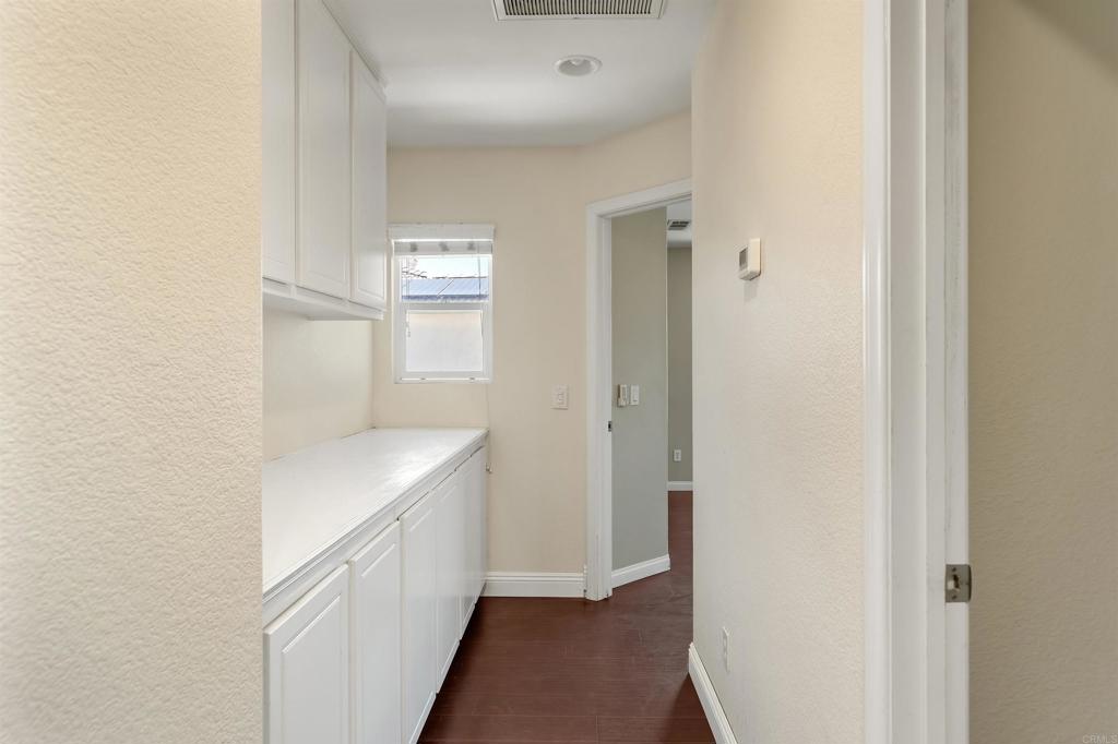 1049 Boulder Place Oceanside, CA 92057 - Photo 30 of 49 a hallway with white cabinets and wooden floor