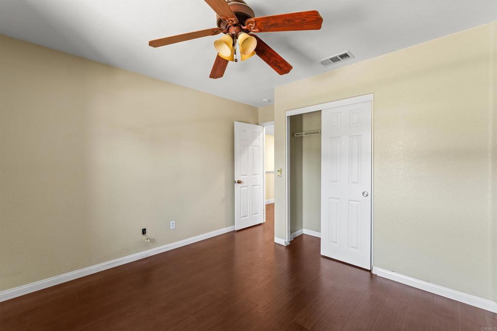1049 Boulder Place Oceanside, CA 92057 - Photo 32 of 49 an empty room with wooden floor closet and fan