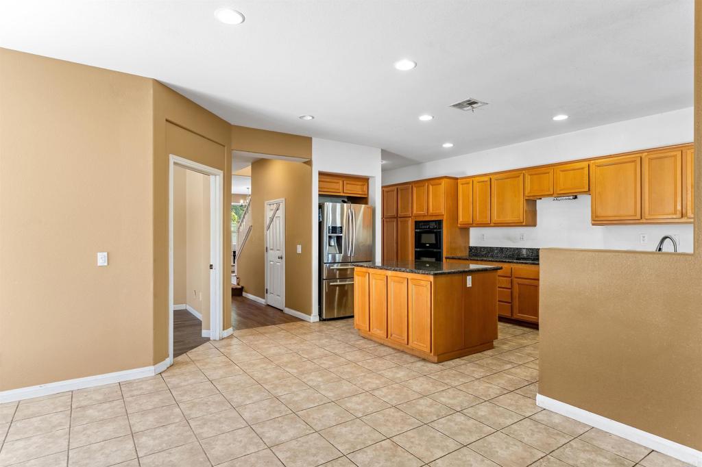 1049 Boulder Place Oceanside, CA 92057 - Photo 9 of 49 a large kitchen with stainless steel appliances a large counter top and a refrigerator