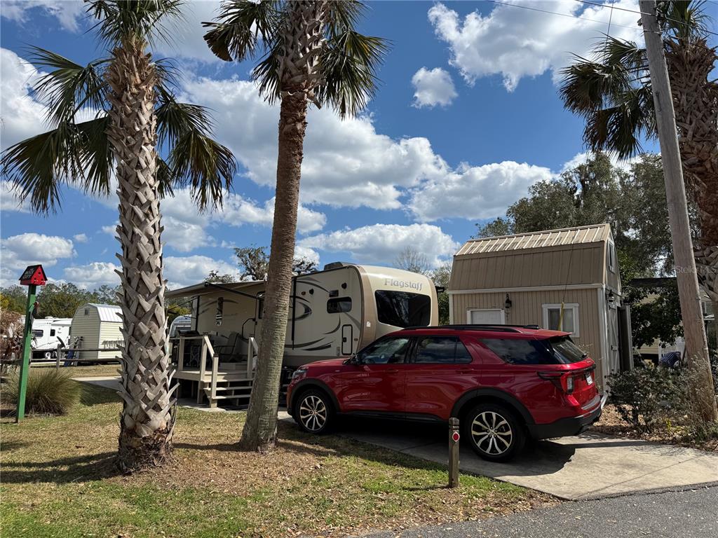 2875 Northeast 102nd Ave Road Silver Springs, FL 34488 - Photo 19 of 68 a front view of a house with a garden and palm trees