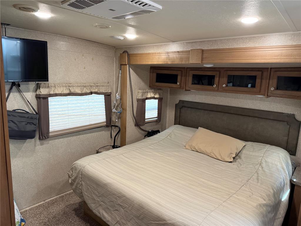 2875 Northeast 102nd Ave Road Silver Springs, FL 34488 - Photo 22 of 68 a bedroom with a large bed and a flat screen tv