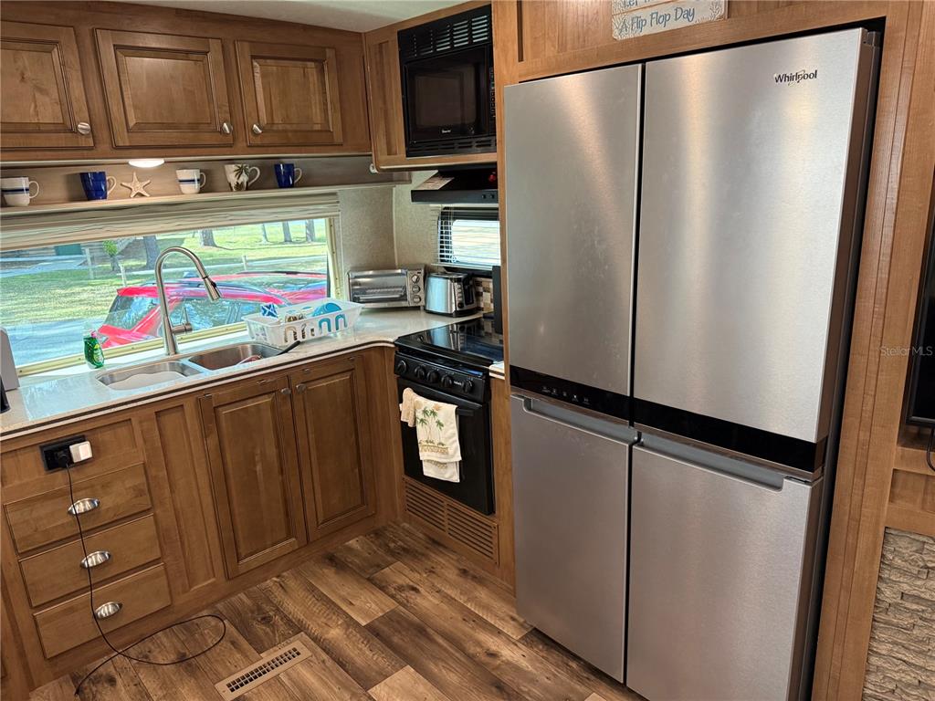 2875 Northeast 102nd Ave Road Silver Springs, FL 34488 - Photo 34 of 68 a kitchen with stainless steel appliances a refrigerator and cabinets