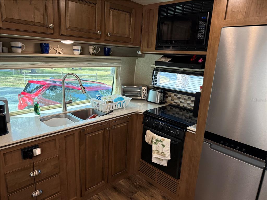 2875 Northeast 102nd Ave Road Silver Springs, FL 34488 - Photo 35 of 68 a kitchen with stainless steel appliances granite countertop a stove and a microwave