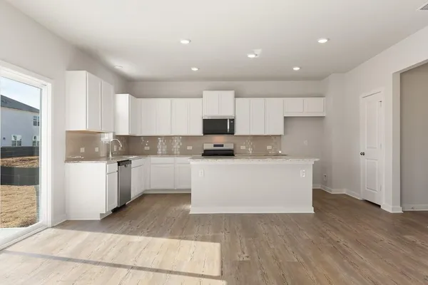 a kitchen with granite countertop white cabinets and white appliances
