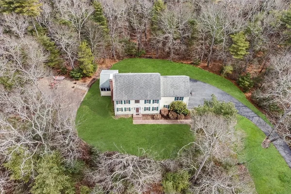an aerial view of a house with a yard and trees