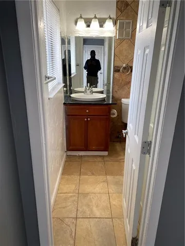 a view of hallway with a mirror and a sink