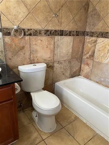 a white toilet sitting next to a bath tub and a shower