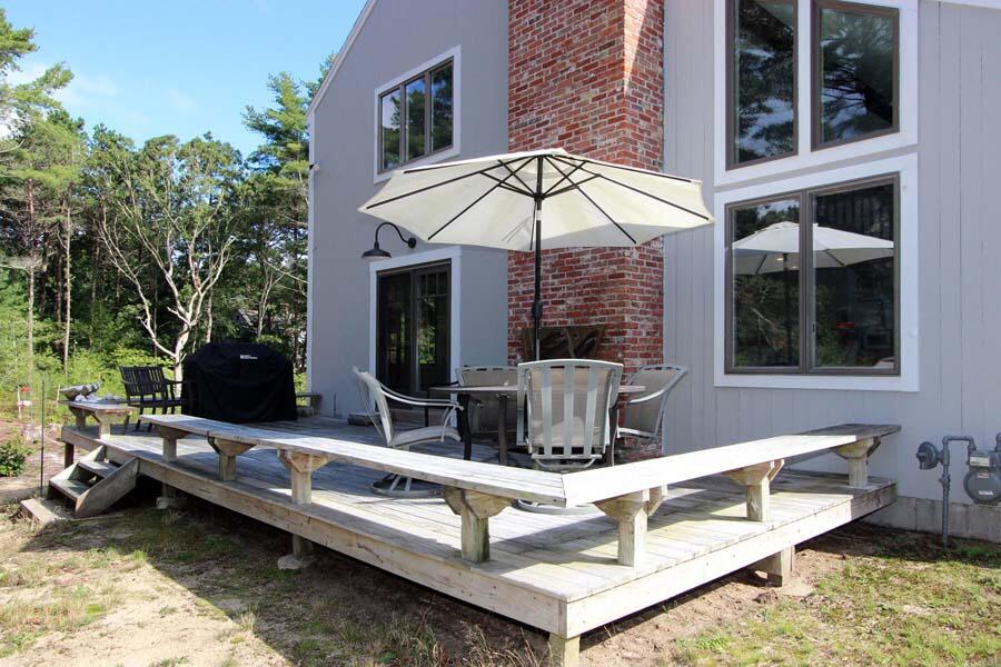 136 West Way Mashpee, MA 02649 - Photo 3 of 30 a view of a patio with couches table and chairs under an umbrella