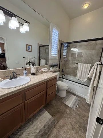 a bathroom with a double vanity sink toilet and shower